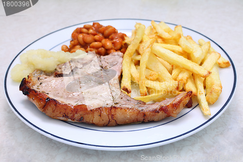 Image of Grilled pork chop fries beans and sauce