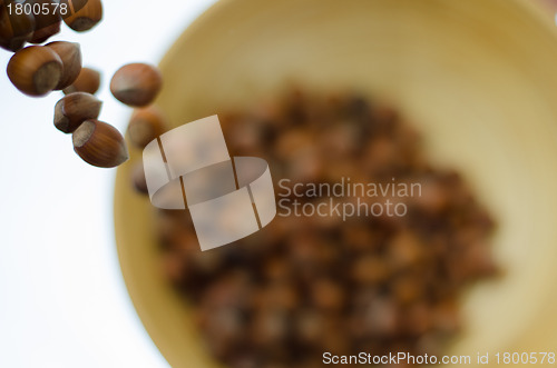 Image of Hazelnuts in Motion Tumbling into Bamboo Bowl