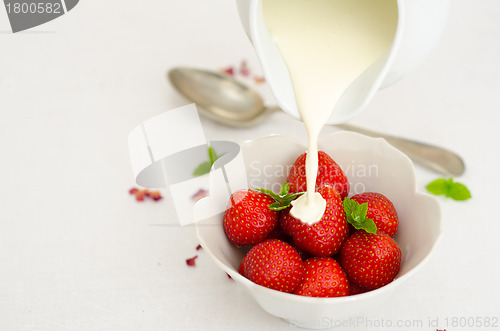 Image of Cream Pouring From a Jug Over Fresh Strawberries