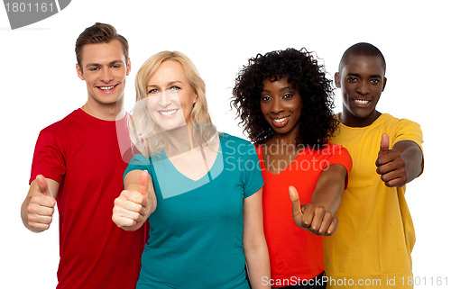 Image of Smiling team of young people showing thumbs up