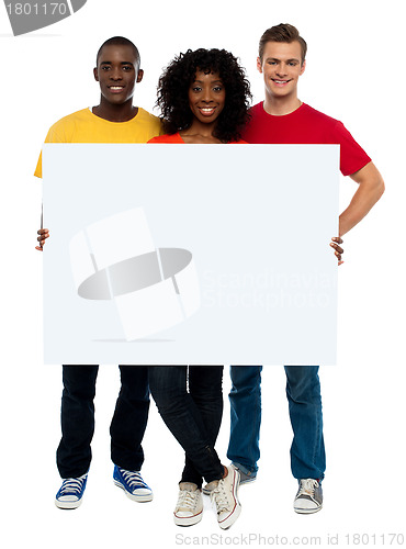 Image of Smiling teenagers presenting blank billboard