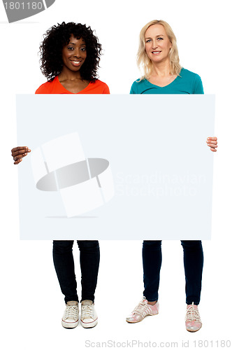 Image of Two young women holding blank billboard