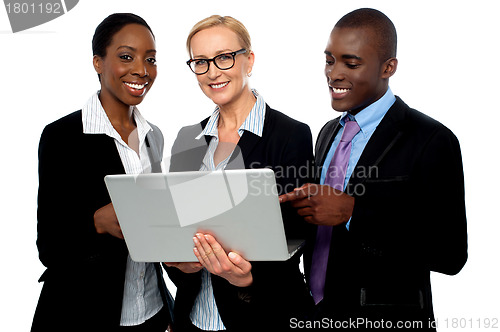 Image of Team of friendly business people using laptop