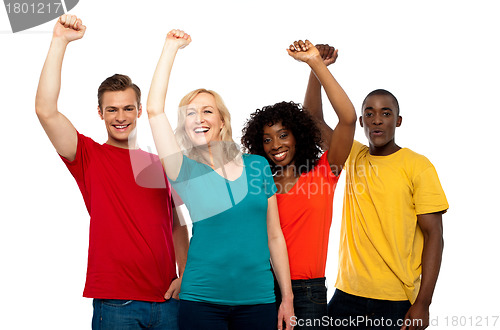 Image of Excited teenager group posing with raised arms