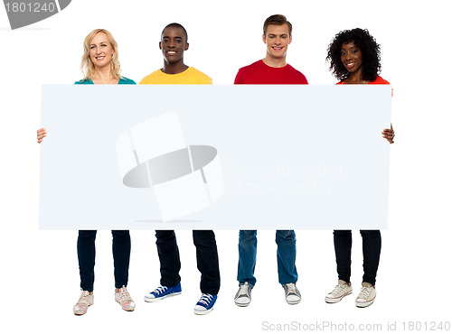 Image of Confident young group showing blank poster