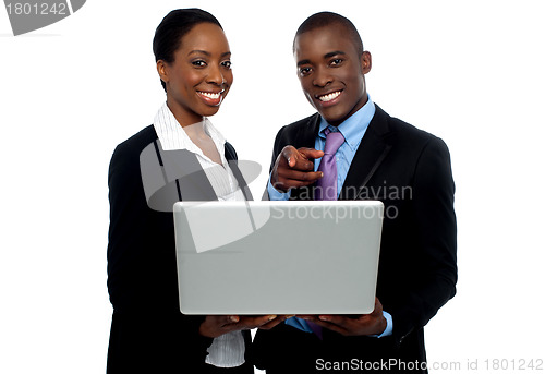 Image of African coworkers operating laptop and pointing