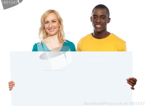 Image of Attractive couple holding white blank ad board