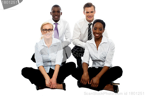 Image of Four business colleagues sitting on floor