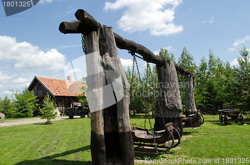 Image of Retro swing carriage hang on chains on tree trunk 