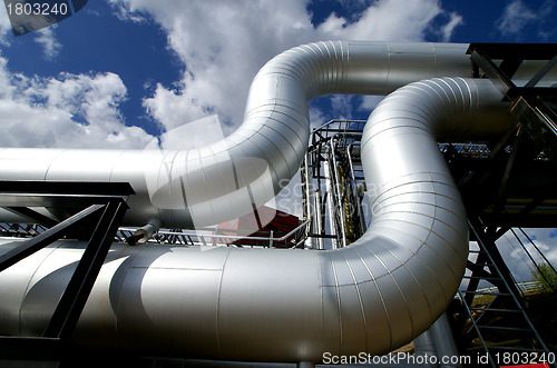 Image of industrial pipelines and valve with a natural blue background