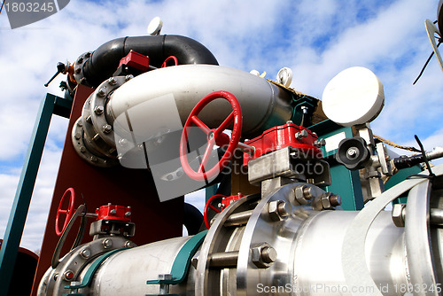 Image of industrial pipelines and valve with a natural blue background