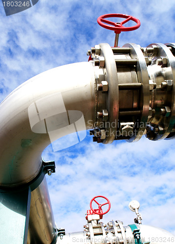 Image of industrial pipelines and valve with a natural blue background