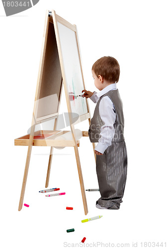 Image of A child paints on an easel in the studio