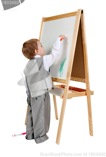 Image of A child paints on an easel in the studio