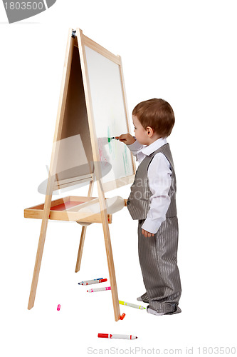 Image of A child paints on an easel in the studio