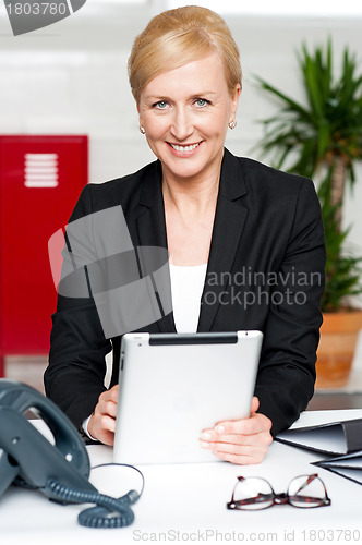 Image of Cheerful businesswoman holding tablet pc