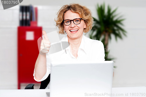 Image of Successful businesswoman gesturing thumbs up