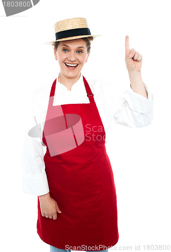 Image of Joyful middle aged cook pointing upwards