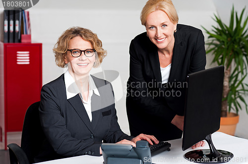 Image of Woman working in office with colleague