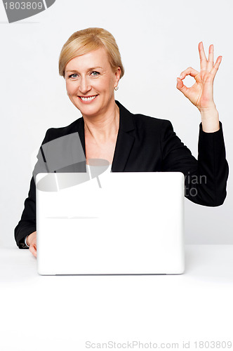 Image of Happy businesswoman gesturing okay sign