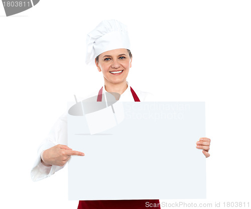 Image of Female chef pointing towards blank whiteboard