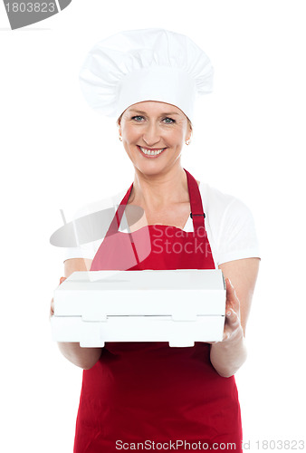 Image of Female baker presenting pizza to you in a box