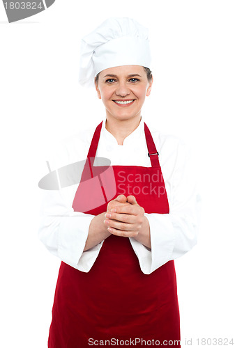 Image of Smiling aged cook standing in red uniform