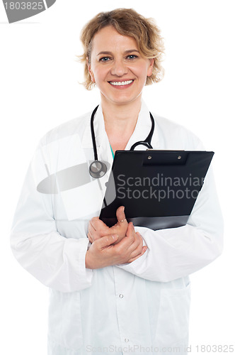 Image of Smiling senior physician holding clipboard