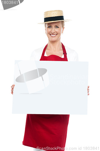 Image of Portrait of female chef in hat with blank ad board
