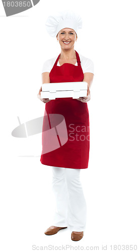 Image of Full length portrait of woman chef offering pizza