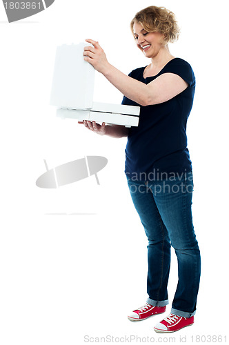 Image of Beautiful woman looking into pizza box