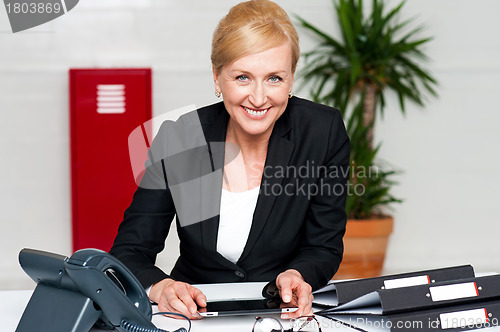 Image of Smiling corporate lady holding wireless tablet