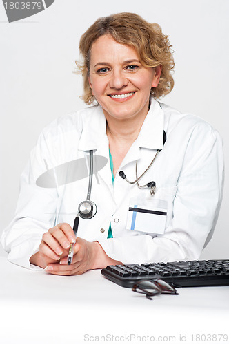 Image of Confident female surgeon sitting idle, holding pen