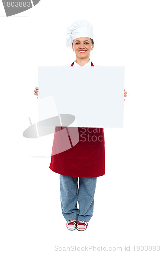 Image of Smiling chef displaying white advertising board