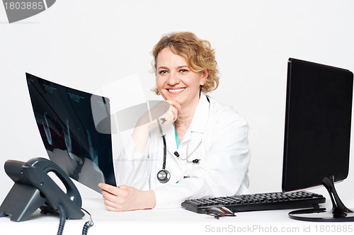 Image of Smiling surgeon holding x-ray report