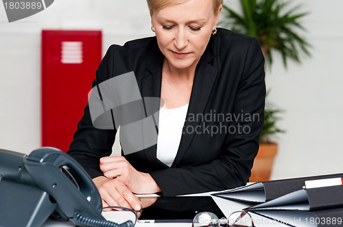 Image of Female executive looking down at tablet screen