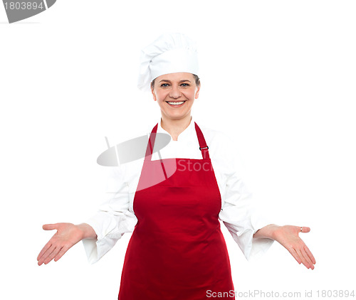 Image of Senior female chef standing with open palms