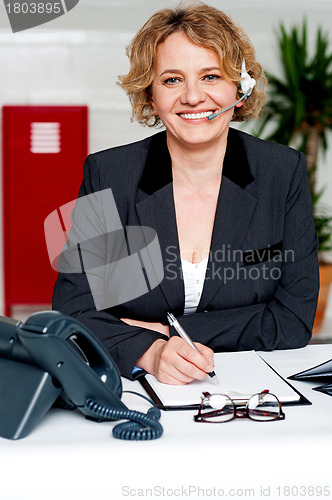 Image of Female executive assisting customers on call