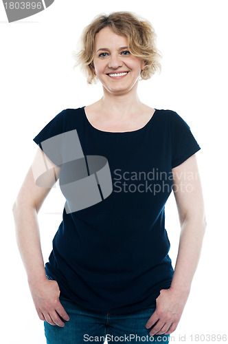 Image of Casual aged woman posing with thumbs on pocket