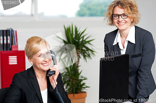 Image of Woman attending call with colleague beside her