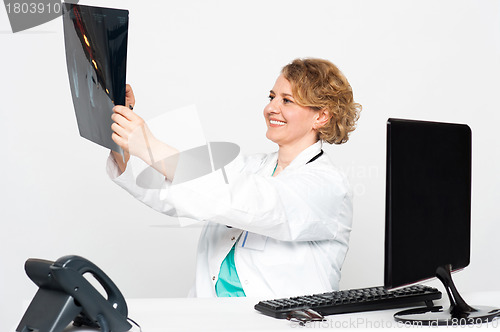 Image of Smiling female surgeon looking at patients x-ray