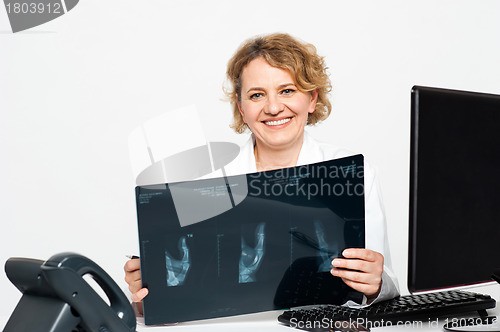 Image of Experienced female surgeon holding x-ray report