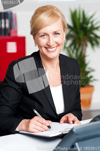 Image of Female secretary writing on notepad