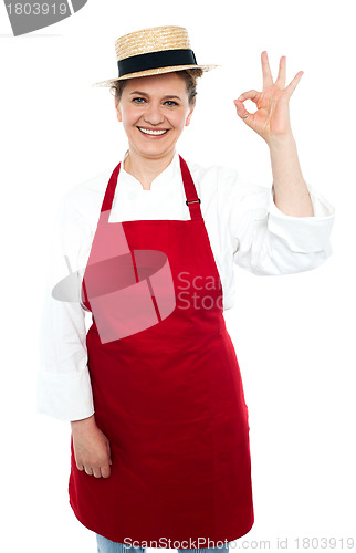 Image of Beautiful woman in hat gesturing excellent sign