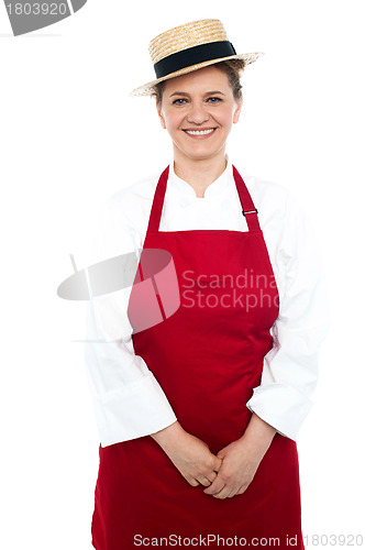 Image of Smiling middle aged female chef wearing hat