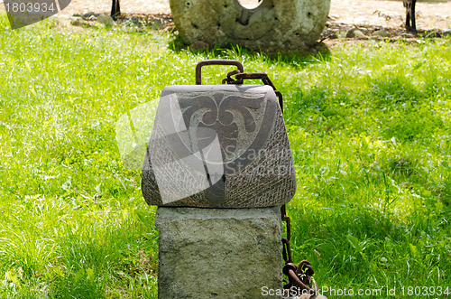 Image of Woman handbag imitation made of stone. Rusty chain 