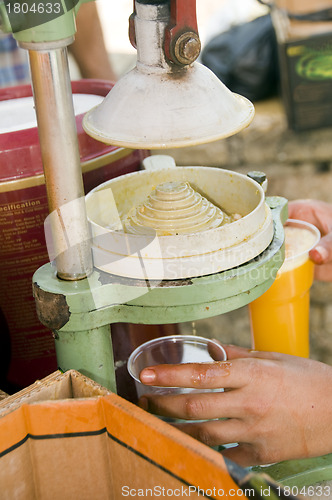 Image of worker squeezing fresh orange juice old fashioned juice press ma