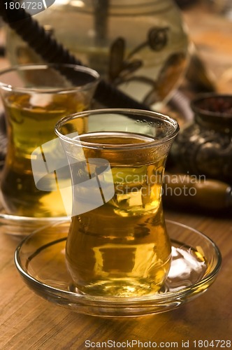 Image of Cup of turkish tea and hookah served in traditional style