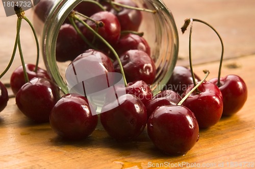 Image of Cherry in glass jar isolated on the wooden background