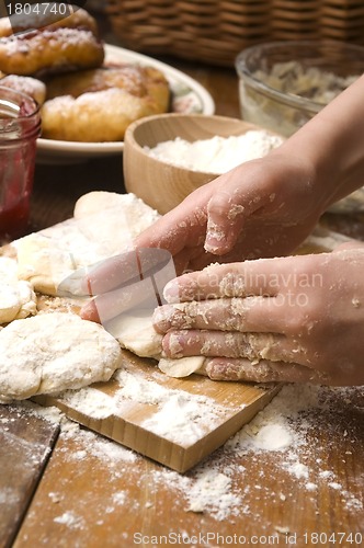 Image of Detail of hands kneading dough